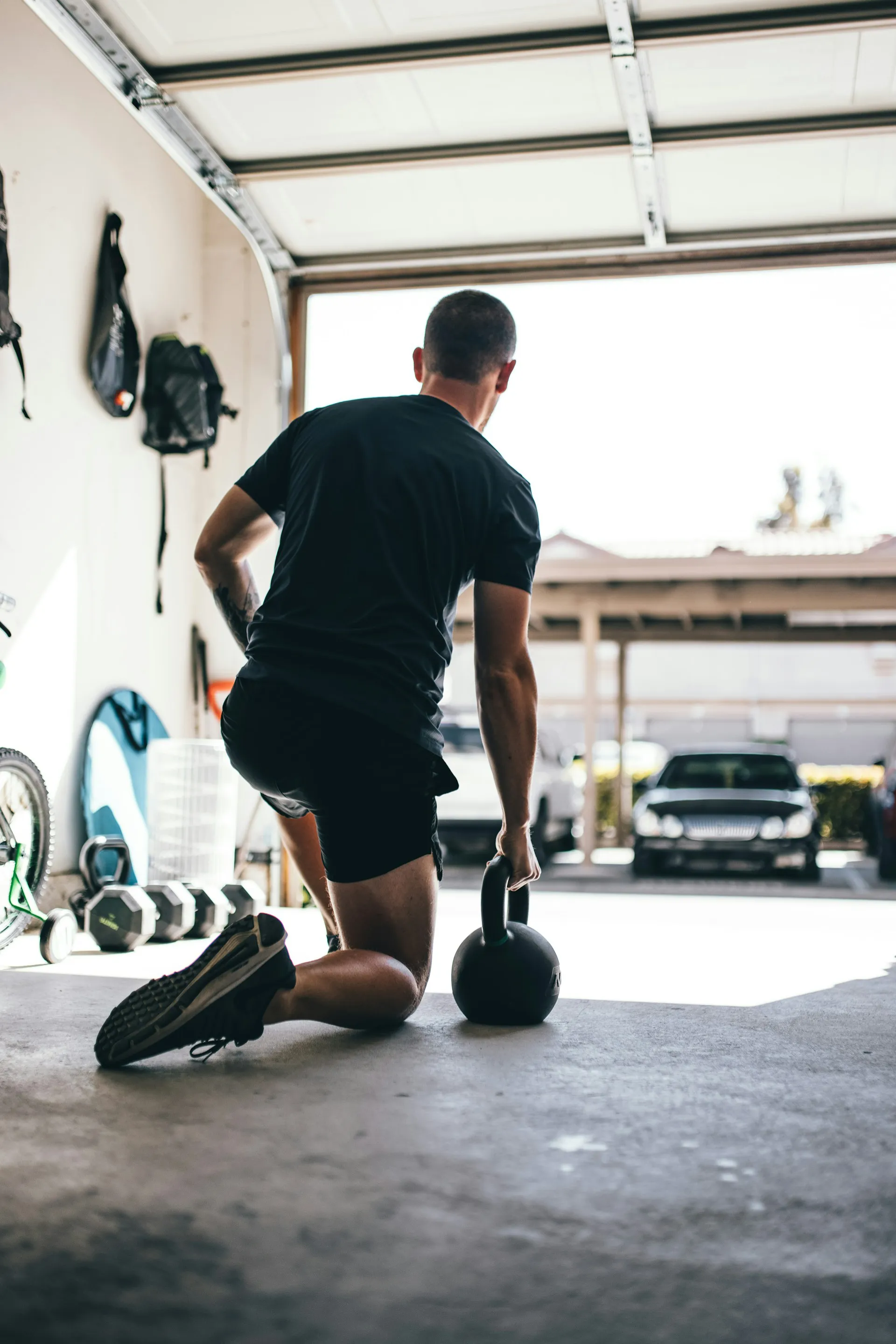 Man kneeling holding a kettlebell.