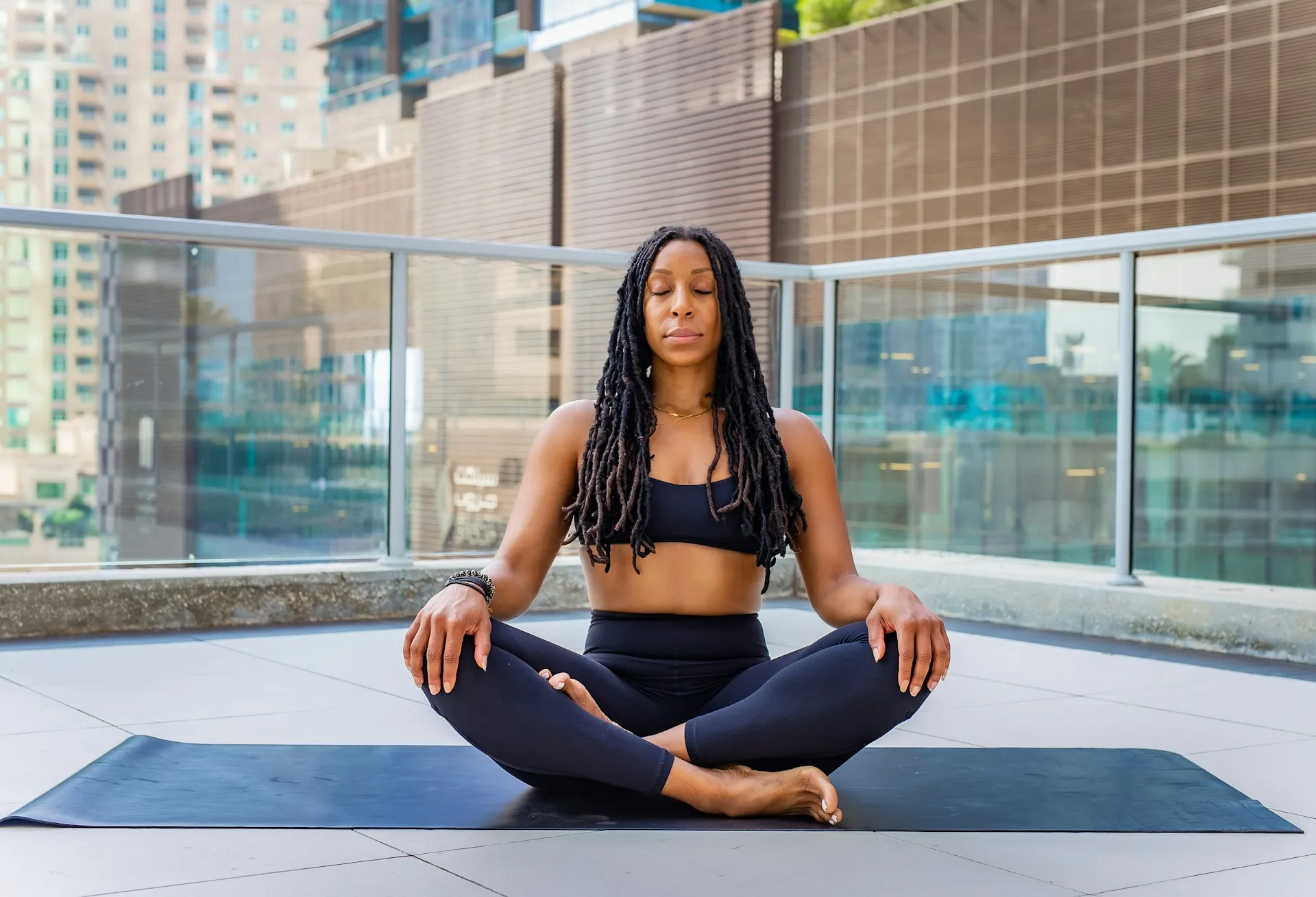 Woman meditating outside on yoga mat